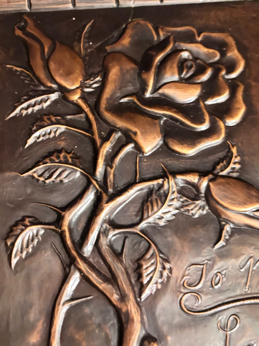 Vintage embossed copper wall plaque features a prominent rose motif